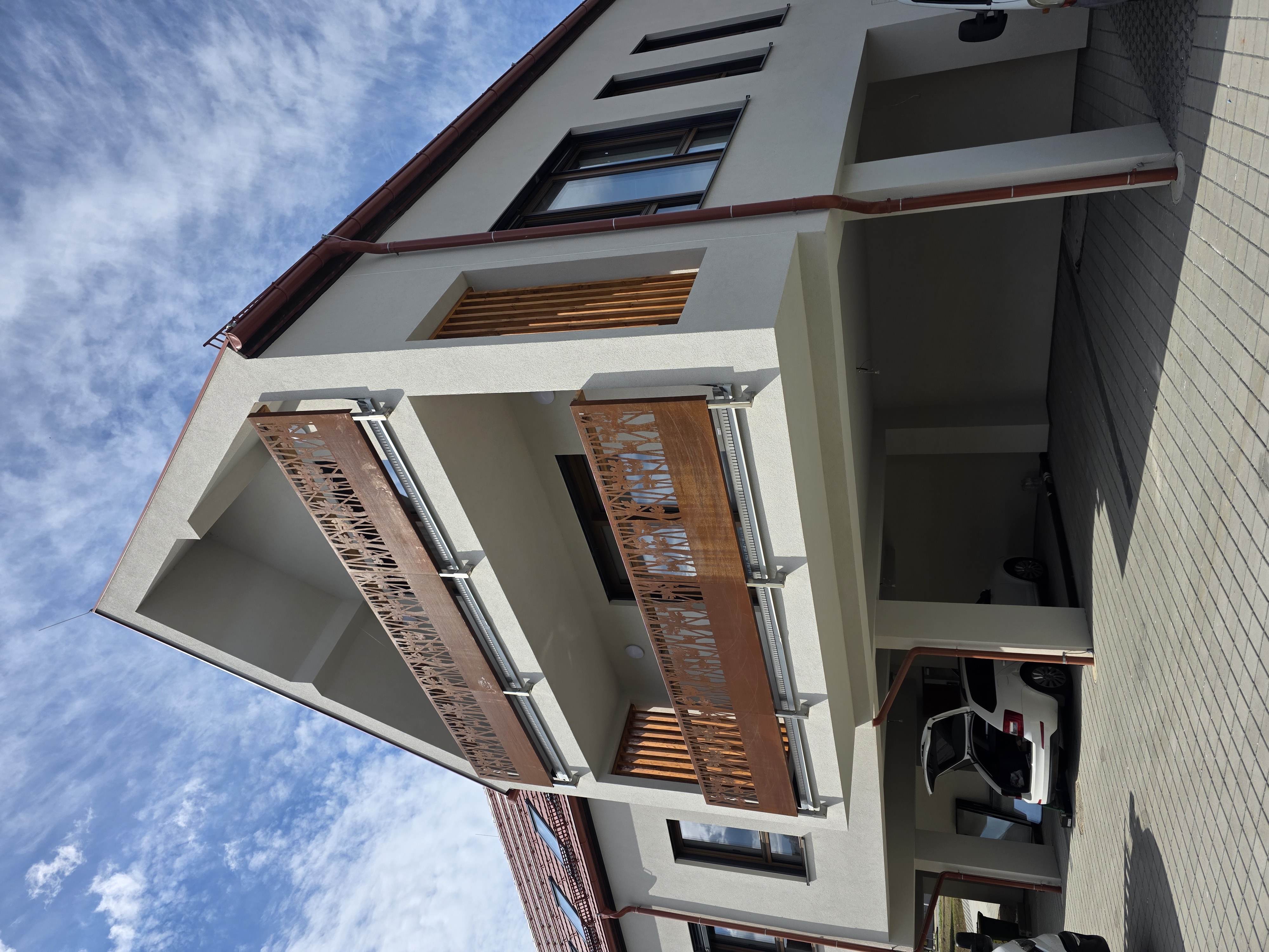 Giebelhaus mit Corten-Balkonen über dem Carport