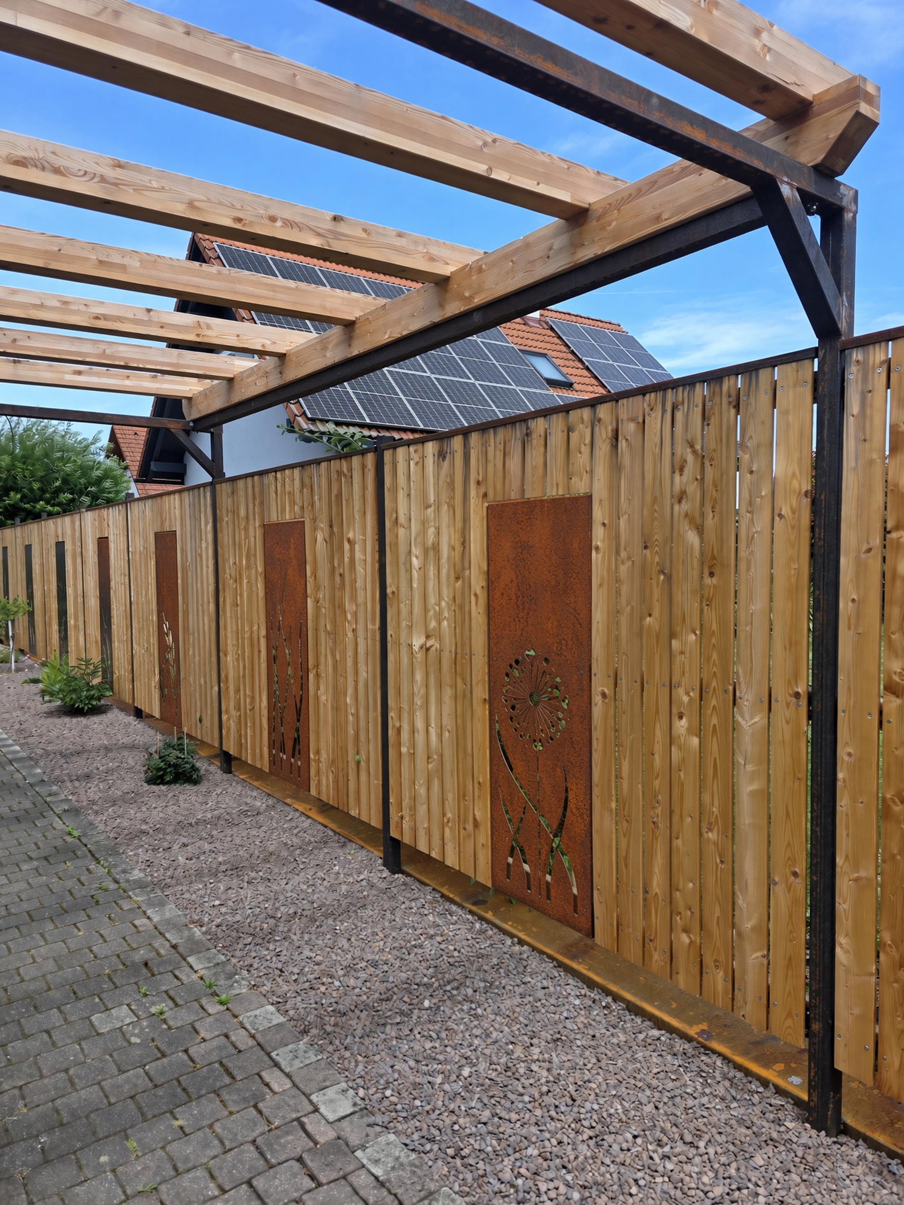 Holz-Sichtschutzwand unter einer Pergola mit lasergeschnittenen Corten-Einlegern